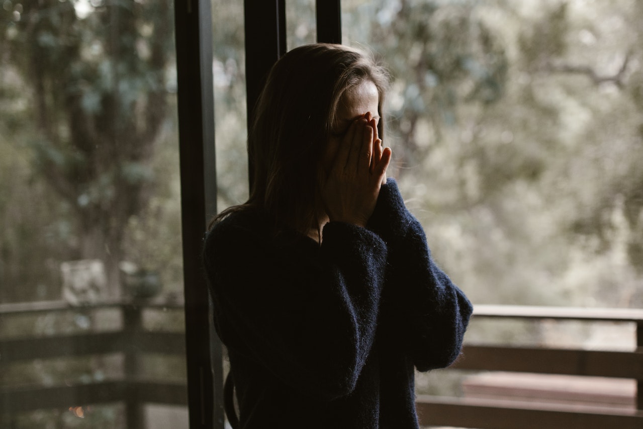 woman with hands over her face